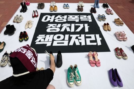 ▲27일 서울 홍대입구역 인근에서 젠더폭력 해결 페미니스트 연대 관계자가 기자회견 시작에 앞서 여성 폭력의 상징인 신발을 놓고 있다. ⓒ연합뉴스