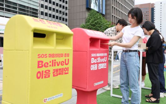 ▲18일 서울 중구 청계광장에서 열린 자살예방을 위한 SOS 마음의 전화 론칭 행사인 '비리브 유(Be:live U) 이음 캠페인'에서 모델이 응원 메시지를 담은 엽서를 우체통에 넣고 있다. ⓒ연합뉴스