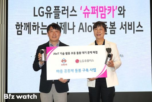 안병경 LG유플러스 홈에이전트 트라이브 그룹장(왼쪽)과 김현아 우리누리 사회적협동조합 이사장이 '마을 공동체 돌봄 구축 사업 고도화' 업무 협약을 체결하고 기념촬영을 하고 있다./사진=LG유플러스 제공