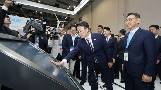 기후산업국제박람회 두산 부스에서 김민석 국무총리(가운데)가 정연인 두산에너빌리티 부회장(오른쪽)의 안내를 받으며 전시 패널을 살펴보고 있다./사진=두산