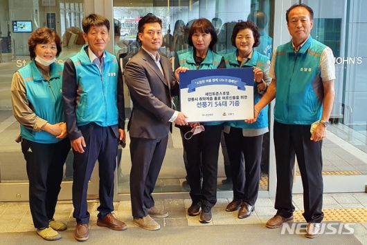 [강릉=뉴시스] 김경목 기자 = ㈜엘케이매니지먼트 세인트존스호텔 관계자가 24일 오후 강원 강릉시 세인트존스호텔에서 우리동네 1촌을 맺은 초당동에 취약계층 홀몸노인 54가구에 전할 선풍기 54대(632만원)를 기증하고 초당동 지역사회보장협의체(공동위원장 전미옥·최종경) 관계자들과 포즈를 취하고 있다. (사진=강릉시청 제공) 2020.07.30. photo＠newsis.com