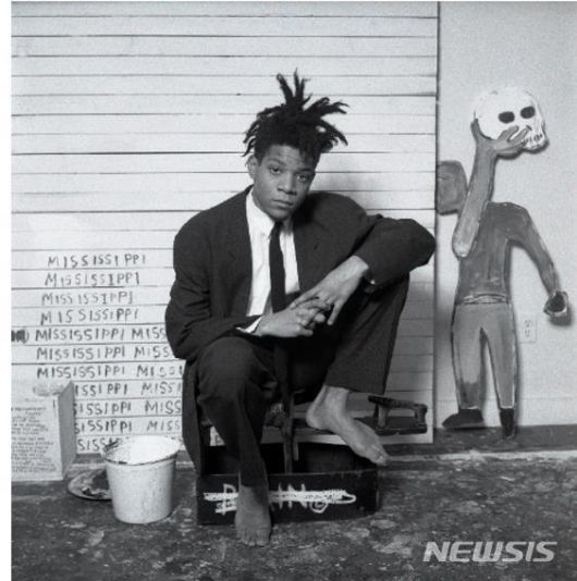 [서울=뉴시스] 장 미쉘 바스키아(1960~1988) Photo ? Dmitri Kasterine. All Rights Reserved. Artwork ? Estate of Jean-Michel Basquiat. Licensed by Artestar, New York’. 1960년 뉴욕 브루클린에서, 아이티공화국 출신의 아버지와 푸에르토리코 계 미국인 어머니 사이에서 태어났다. 프랑스어가 모국어였던 아버지와 스페인어 를 쓰는 어머니 밑에서 성장한 바스키아는 영어와 프랑스어, 스페인어를 완벽하게 구사할 수 있었고, 이것은 그의 작품 속에 다양한 언어를 표현하는 초석이 된다.
