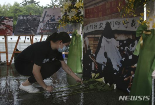 [타이베이=AP/뉴시스] 대만 수도 타이베이 민주광장에서 2021년 6월 4일 코로나19 예방을 위해 마스크를 착용한 여성이 중국군이 민주화 시위대를 유혈진압한 톈안먼 사태 32주년을 맞아 희생자를 추모하는 제단에 헌화하고 있다. 2024.08.22.