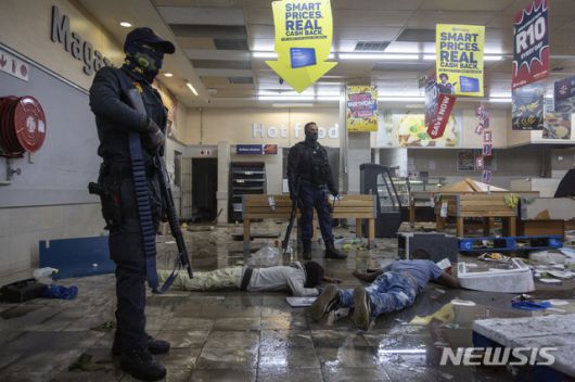 [요하네스버그=AP/뉴시스] 12일(현지시간) 남아프리카공화국 요하네스버그의 한 상점에서 경찰이 약탈범들을 체포하고 있다. 경찰은 제이콥 주마 전 대통령의 수감 이후 폭동과 약탈이 고조되면서 6명이 숨지고 200명 이상이 체포됐다고 밝혔다. 2021.07.13.