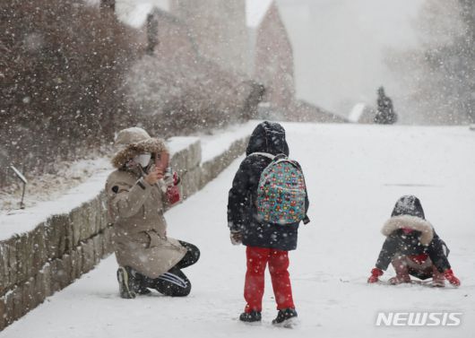 '찰칵, 사진으로 남겨놔야지' [서울=뉴시스] 조수정 기자 = 올 겨울 첫 대설주의보가 발령된 18일 오후 서울 서대문구에서 어린이들이 엄마아빠와 눈싸움을 하고 있다. chocrystal@newsis.com