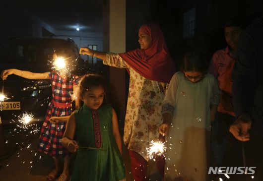 [인도=AP/뉴시스] 시민들이 24일(현지시간) 인도에서 열린 힌두교 최대 축제인 디왈리를 기념해 폭죽에 불을 붙이고 있다. 2022.10.25.