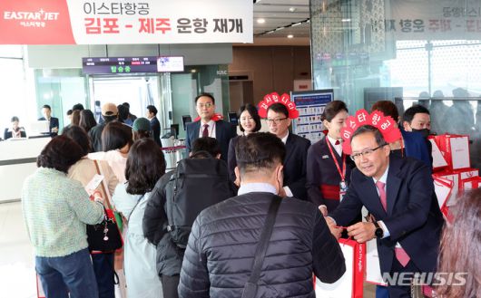 [서울=뉴시스] 최동준 기자 = 조중석 이스타항공 대표를 비롯한 임직원들이 26일 오전 김포국제공항 국내선 탑승 게이트에서 승객들에게 기념품을 나눠주고 있다. 이스타 항공은 오늘부터 김포-제주 노선을 시작으로 3년 만에 운항을 재개했다. (공동취재사진) 2023.03.26. photo@newsis.com