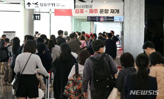 [서울=뉴시스] 최동준 기자 = 26일 김포공항 국내선 탑승동 게이트에서 이스타항공 승객들이 비행기 탑승을 위해 줄을 서 있다. 이날 이스타항공은 지난 2020년 3월 24일 경영난으로 운항을 중단한 후 3년 만에 운항을 재개했다. (공동취재사진) 2023.03.26. photo@newsis.com