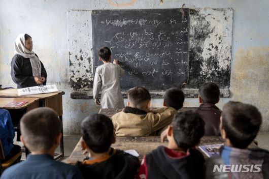 [카불=AP/뉴시스]2023년 3월25일 카불의 학교에서 남학생들이 여교사와 수업하고 있다. 아프가니스탄 집권 탈레반은 아프간에서 여성을 고용하는 모든 국내외 비정부기구(NGO)들을 폐쇄할 것이라고 30일 밝혔다. 탈레반은 이미 2년 전 NGO에 고용된 아프간 여성들이 이슬람 두건을 제대로 쓰지 않는다는 이유로 여성 고용을 금지한다고 지시했었지만 잘 지켜지지 않자 새 조치로 폐쇄를 위협한 것이다. 2024.12.30.