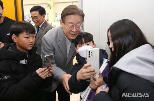 [서울=뉴시스] 국회사진기자단 = 이재명 더불어민주당 대표가 6일 오후 서울 강서구 방화초등학교에서 ’온동네 초등돌봄' 현장간담회에 참석하기 전 돌봄교실을 둘러보며 학생들과 기념촬영을 하고 있다. 2023.12.06. photo@newsis.com