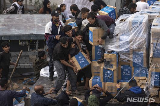 [라파=AP/뉴시스] 17일(현지시각) 가자지구 라파에서 팔레스타인 난민들이 인도주의적 구호 물품을 실은 트럭을 약탈하고 있다. 2023.12.18.