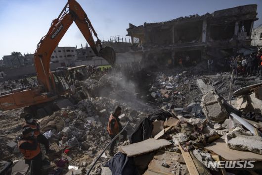 [라파=AP/뉴시스] 19일(현지시각) 가자지구 라파의 팔레스타인인들이 이스라엘의 폭격으로 무너진 건물 잔해 속에서 희생자 시신을 찾고 있다. 2023.12.20.