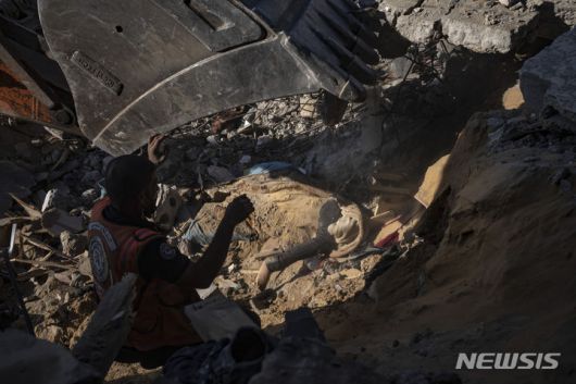[라파=AP/뉴시스] 19일(현지시각) 가자지구 라파의 팔레스타인인들이 이스라엘의 폭격으로 무너진 건물 잔해 속에서 희생자 시신을 수습하고 있다. 2023.12.20.
