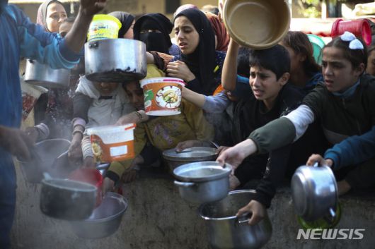 [라파=AP/뉴시스] 20일(현지시각) 가자지구 남부 라파의 급식소에 무료 음식을 받으려는 팔레스타인 주민들이 몰려들고 있다. 2023.12.21.