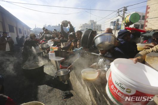 [라파=AP/뉴시스] 20일(현지시각) 가자지구 남부 라파의 급식소에 무료 음식을 받으려는 팔레스타인 주민들이 몰려들고 있다. 2023.12.21.