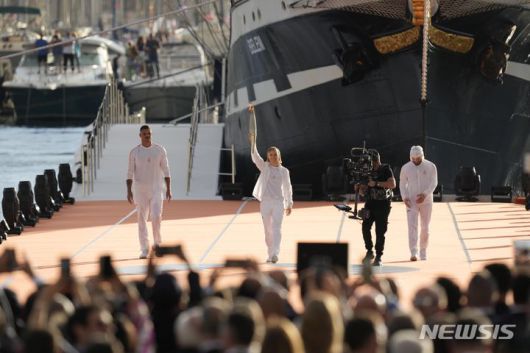[마르세유=AP/뉴시스] 프랑스 패럴림픽 선수 난테닌 케이타(가운데)가 프랑스 남부 마르세유에서 열린 성화 도착식에서 성화를 들고 있다. 2024.05.09.