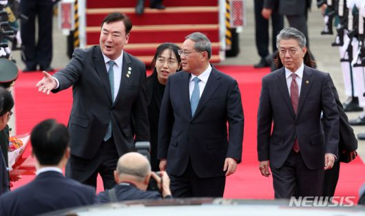 [성남=뉴시스] 김금보 기자 = 한일중 정상회의에 참석하는 리창(가운데) 중국 총리가 26일 서울 성남공항에 도착해 싱하이밍(왼쪽) 주한중국대사에게 영접인사들을 소개받고 있다. 오른쪽은 김홍균 외교부 1차관. 2024.05.26. kgb@newsis.com