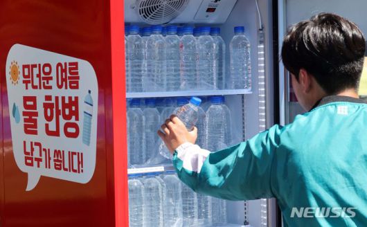 [부산=뉴시스] 하경민 기자 = 부산 남구 평화공원에 마련된 냉장고에서 시민들이 생수를 꺼내고 있다.  2024.07.31. yulnetphoto@newsis.com