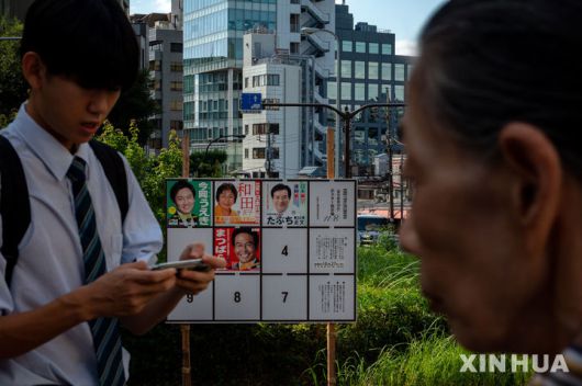 [도쿄=신화/뉴시스]일본 시민들이 지난해 10월 15일 일본 도쿄에서 진행 중인 중의원 선거 캠페인을 위한 게시판을 지나가고 있다. 2024.10.22.