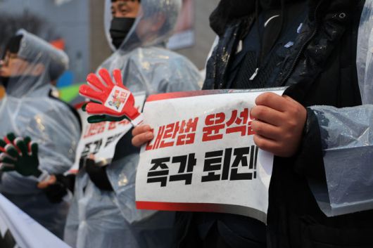 [천안=뉴시스] 박우경 기자=5일 충남 천안종합터미널 앞에서 한 시민이 윤석열 대통령의 사퇴를 촉구하는 손 팻말을 들고 있다. 2024.12.5. spacedust1@newsis.com *재판매 및 DB 금지