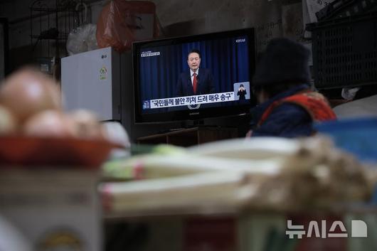 [서울=뉴시스] 정병혁 기자 = 7일 서울 서대문구 인왕시장에서 상인들이 윤석열 대통령의 대국민담화를 시청하고 있다. 2024.12.07. jhope@newsis.com