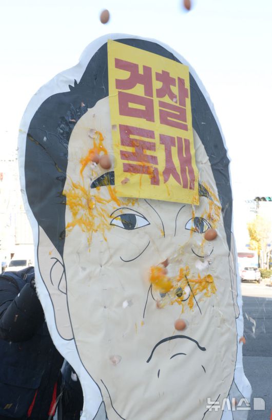 [울산=뉴시스] 배병수 기자 = 민주노총 울산지역본부가 9일 울산 남구 국민의힘 울산시당앞에서 윤 대통령 탄핵 부결! 국민의힘 규탄!을 촉구하는 기자회견 뒤 계란던지기 퍼포먼스를 하고 있다. 2024.12.09.bbs@newsis.com.