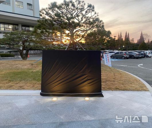[창원=뉴시스]한국산업단지공단 경남지역본부 청사 앞에 설치되어 있는 윤석열 대통령 친필 표지석에 민주노총 경남본부에서 지난 10일 오후 대통령 윤석열 글자 앞에 검은색 스프레이로 '내란'을 추가했고, 표지석 소유자인 창원시에서는 11일 현재까지 표지석을 천으로 가려놓고 있다.(사진=독자 제공) 2024.12.11. photo@newsis.com