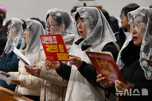 [광주=뉴시스] 이영주 기자 = 12일 오후 광주 동구 남동5·18기념성당에서 열린 '대한민국의 올바른 정의와 평화를 위한 시국미사'에서 신도들이 윤석열 대통령 탄핵과 국민의힘 해체를 촉구하는 손팻말을 들고 있다. 2024.12.12. leeyj2578@newsis.com