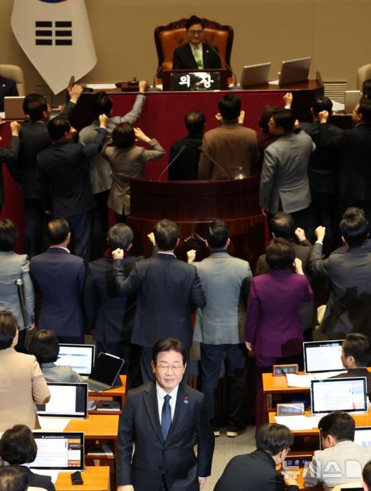 [서울=뉴시스] 권창회 기자 = 이재명 더불어민주당 대표가 27일 오후 서울 여의도 국회에서 열린 제420회국회(임시회) 제2차 본회의에서 국무총리(한덕수) 탄핵소추안 투표를 마친뒤 항의하는 국민의힘 의원들 뒤로 미소 지으며 이동하고 있다. 2024.12.27. kch0523@newsis.com