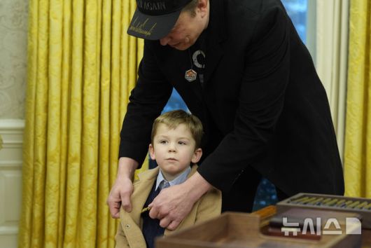 [워싱턴=AP/뉴시스] 일론 머스크가 11일(현지 시간) 워싱턴DC 백악관 대통령 집무실에서 아들 엑스 애쉬 에이 트웰브(X Æ A-Xii)의 옷매무새를 정리하고 있다. 2025.02.12.