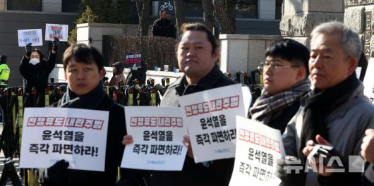 [서울=뉴시스] 홍효식 기자 = 21일 서울 종로구 헌법재판소 앞에서 자주통일평화연대 주최로 전쟁유도 내란범죄자 윤석열 파면 촉구 기자회견이 진행되는 가운데 탄핵 반대 시민들이 부정선거 중단 관련 피켓을 들고 있다. 2025.02.21. yesphoto@newsis.com