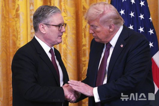 [워싱턴=AP/뉴시스] 도널드 트럼프(오른쪽) 미국 대통령과 키어 스타머 영국 총리가 지난달 27일(현지 시간) 백악관 이스트룸에서 공동 기자회견 중 악수하고 있다. 2025.03.31.