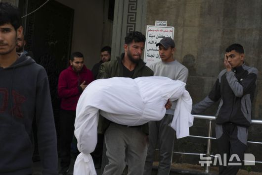 [가자지구=AP/뉴시스] 18일(현지 시간) 가자지구 가자시티 시파 병원에서 팔레스타인인들이 이스라엘군 공습으로 숨진 희생자의 시신을 옮기고 있다. 2025.03.18.