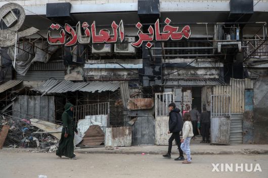 [가자시티=신화/뉴시스] 1일(현지 시간) 가자지구 북부 가자시티에서 주민들이 문 닫은 빵집 앞을 지나고 있다. 2025.04.02.