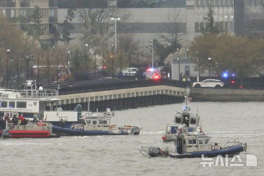 [뉴욕=AP/뉴시스] 10일(현지시간) 미국 뉴욕 허드슨 강 헬기 추락 현장에서 경찰과 소방대원이 실종자를 수색하고 있다. 2025.04.11.