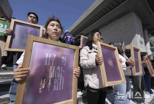 [서울=뉴시스] 김근수 기자 = 기후위기비상행동과 기후정치바람 회원들이 지난달 15일 서울 종로구 세종문화회관 앞에서 열린 기후 단일 의제 대선 TV 토론회 촉구 기자회견에서 캠페인 슬로건이 적힌 실크스크린을 들고 서 있다. 2025.04.15. ks@newsis.com