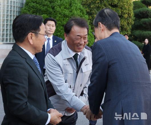 [광주=뉴시스] 조수정 기자 = 한덕수 대통령 권한대행 국무총리가 15일 광주 서구 기아오토랜드 광주공장에서 자동차산업 현장방문을 위해 도착해 최준영 기아 사장과 인사나누고 있다. 왼쪽은 강기정 광주광역시장. 2025.04.15. chocrystal@newsis.com
