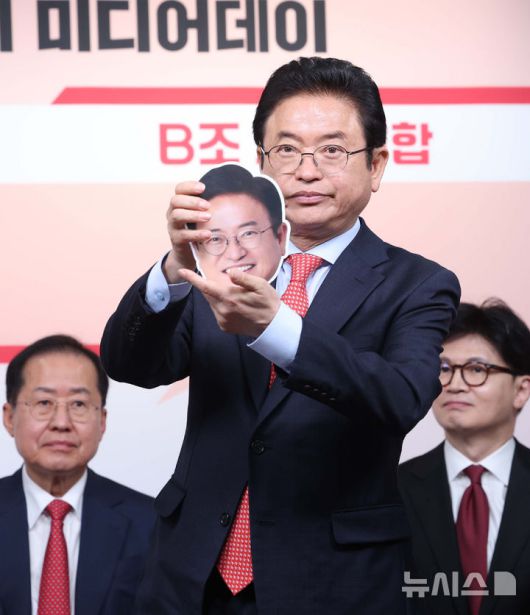 [서울=뉴시스] 국회사진기자단 = 17일 서울 여의도 국민의힘 중앙당사에서 열린 제21대 대통령선거 '1차 경선 토론회 미디어데이' 행사에서 이철우(가운데) 후보가 얼굴 사진을 들어 보이고 있다. 왼쪽부터 홍준표, 이철우, 한동훈 후보. 2025.04.17. photo@newsis.com