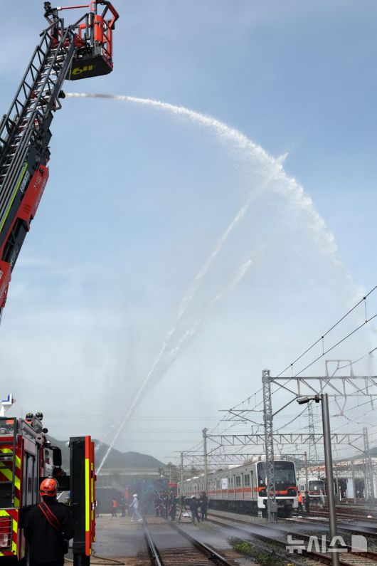 [부산=뉴시스] 하경민 기자 = 2025년 충무훈련의 하나로 '도시철도 피해복구 종합 실제훈련'이 열린 23일 부산 금정구 도시철도 1호선 노포차량정비창에서 소방이 테러로 인한 화재를 진압하고 있다. 전시 적 공격으로 인한 도시철도 시설피해 발생에 대비한 민·관·군·경·소방 합동훈련에는 53사단 부산여단과 부산교통공사, 금정구청, 금정소방서, 보건소, 부산항만공사, 금정결찰서 등 7개 기관 200여 명이 참가했다. 2025.04.23. yulnetphoto@newsis.com