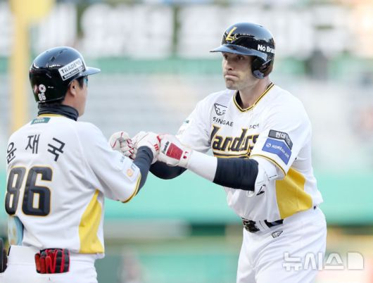 [서울=뉴시스] 프로야구 SSG 랜더스 라이언 맥브룸(오른쪽)이 25일 인천 SSG랜더스필드에서 열린 2025 신한 쏠뱅크 KBO리그 키움 히어로즈와의 경기에서 적시타를 친 뒤 윤재국 코치와 손을 맞대고 있다. (사진=SSG 랜더스 제공) 2025.04.25.