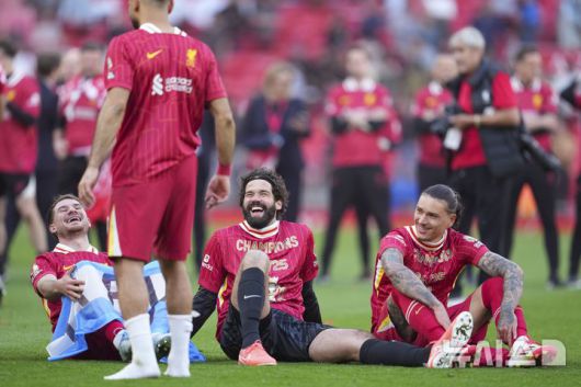 [리버풀=AP/뉴시스] 리버풀 선수들이 27일(현지 시간) 영국 리버풀의 안필드에서 열린 2024-25 프리미어리그 34라운드 토트넘 홋스퍼와의 경기에서 승리해 리그 우승을 확정한 후 운동장에 앉아 활짝 웃고 있다. 리버풀은 손흥민이 부상으로 빠진 토트넘에 5-1로 승리하고 남은 경기 결과에 상관없이 우승을 확정했다. 2025.04.28.