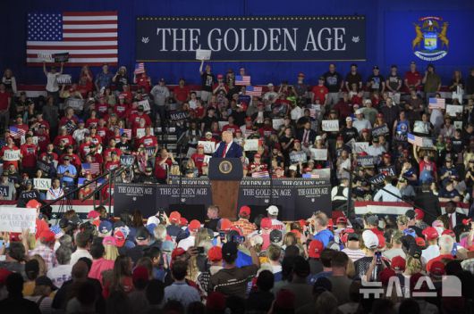 [워런(미시간주)=AP/뉴시스] 도널드 트럼프 미국 대통령이 지난달 29일(현지 시간) 미시간주 워런의 머콤 카운티 커뮤니티 컬리지 스포츠 엑스포 센터에서 열린 취임 100일 기념 집회에서 지지자들의 환호에 포즈를 취하고 있다. 2025.05.20.