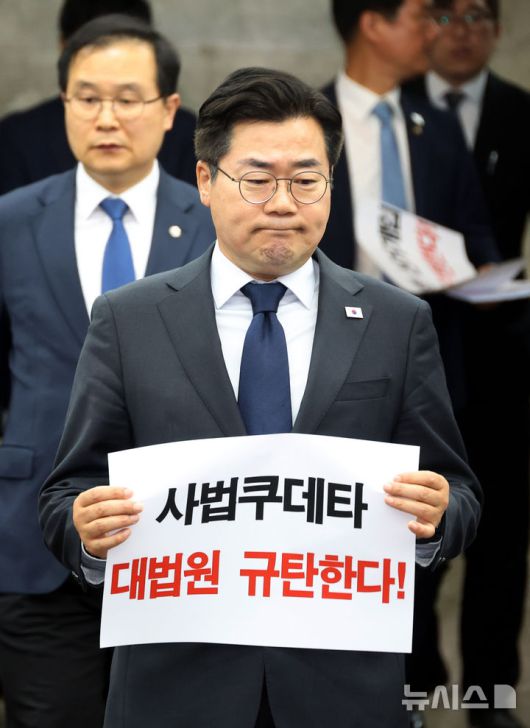 [서울=뉴시스] 조성봉 기자 = 박찬대 더불어민주당 대표 직무대행 겸 원내대표가 1일 오후 서울 여의도 국회에서 열린 긴급 의원총회에서 손피켓을 들고 굳은 표정으로 참석하고 있다. 2025.05.01. suncho21@newsis.com