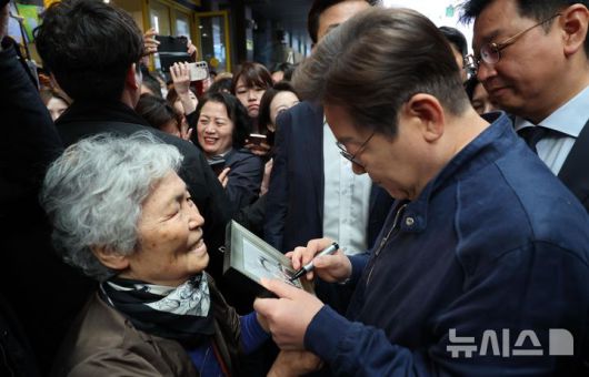 [철원=뉴시스] 조성우 기자 = 민심을 청취하는 '경청 투어'에 나선 이재명 더불어민주당 대선후보가 2일 오전 강원도 철원군 동송시외버스공용터미널 인근에서 주민을 만나 사인해주고 있다. 2025.05.02. xconfind@newsis.com