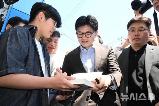 [창원=뉴시스] 차용현 기자 = 2일 오전 경남 창원시 마산어시장을 방문한 한동훈 제21대 대통령 선거 국민의힘 경선 후보가 시민에게 사인을 해주고 있다. 2025.05.02.con@newsis.com