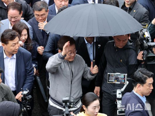 [속초=뉴시스] 조성우 기자 = 민심을 청취하는 '경청 투어'에 나선 이재명 더불어민주당 대선후보가 3일 강원도 속초시 속초중앙시장을 방문하기 위해 차에서 내려 경호를 받으며 이동하고 있다. 이 후보 측은 "후보에 대한 피습 모의 제보가 잇따르고 있다"고 밝혔다. 2025.05.03. xconfind@newsis.com