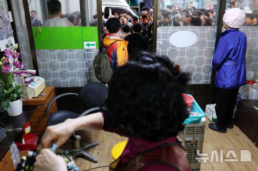 [양양=뉴시스] 조성우 기자 = 민심을 청취하는 '경청 투어'에 나선 이재명 더불어민주당 대선후보가 3일 강원도 양양군 양양시장에서 상인 및 주민들에게 인사를 하는 가운데 시장 내 한 미용실에서 상인과 고객들이 이 후보 쪽을 바라보고 있다. 2025.05.03. xconfind@newsis.com