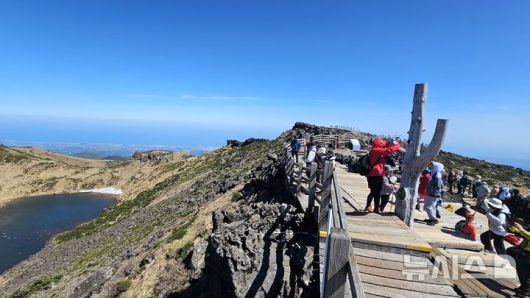 [제주=뉴시스] 임재영 기자 = 4일 오전 한라산 정상인 백록담에서 탐방객들이 선명하게 드러난 분화구 장관을 감상하고 있다. 2025.05.04. ijy788@newsis.com