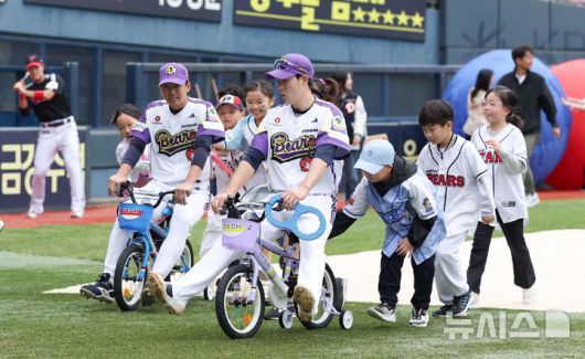 [서울=뉴시스] 김선웅 기자 = 어린이날인 5일 서울 송파구 잠실야구장에서 열린 2025 프로야구 LG 트윈스 vs 두산 베어스의 경기 시작 전 두산 박지훈, 김민석이 어린이용 자전거를 타고 어린이날 기념 미니 운동회에 참여하고 있다. 2025.05.05. mangusta@newsis.com