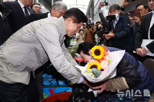 [포항=뉴시스] 권창회 기자 = 김문수 국민의힘 대선 후보가 6일 경북 포항시 죽도시장을 방문해 상인들에게 꽃다발을 선물하고 있다. 2025.05.06. kch0523@newsis.com